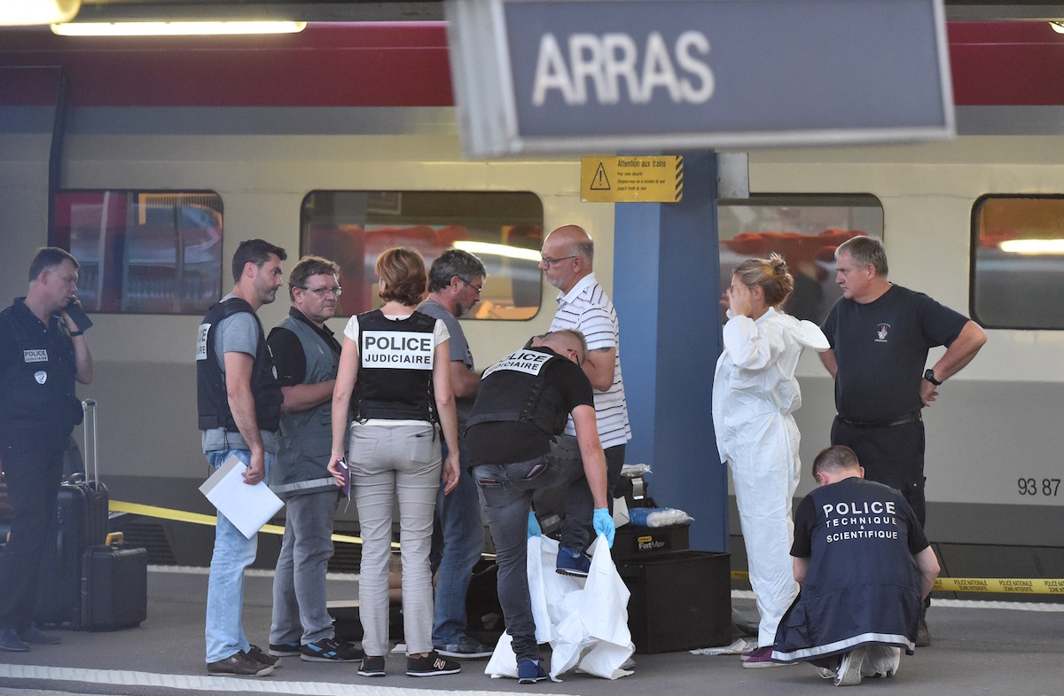 Criminal and forensic investigators put on protective suits on a platform next to a Thalys train of French national railway operator SNCF at the main train station in Arras, northern France, on August 21, 2015. A gunman opened fire on a train travelling from Amsterdam to Paris, injuring three people before being overpowered by passengers, French state rail company SNCF and rescue services said. Two of the victims were seriously injured and at least one suffered gunshot wounds, an SNCF spokesman said, adding that the assailant was armed with guns and knives. The motives behind the attack were not immediately known. AFP PHOTO / PHILIPPE HUGUEN        (Photo credit should read PHILIPPE HUGUEN/AFP/Getty Images)